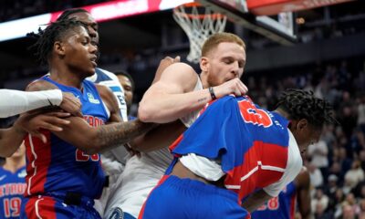 Minnesota Timberwolves guard Donte DiVincenzo (0), middle, and Detroit Pistons forward Ronald Holland II (00), right, fight during the first half of an NBA basketball game, Sunday, March 30, 2025, in Minneapolis. (AP Photo/Abbie Parr)