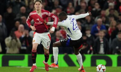 Lyon's Clinton Mata, right, and Manchester United's Alejandro Garnacho challenge for the ball during the Europa League quarter final second leg soccer match between Manchester United and Olympique Lyon in Manchester, Britain, Thursday, April 17, 2025. (AP Photo/Jon Super)