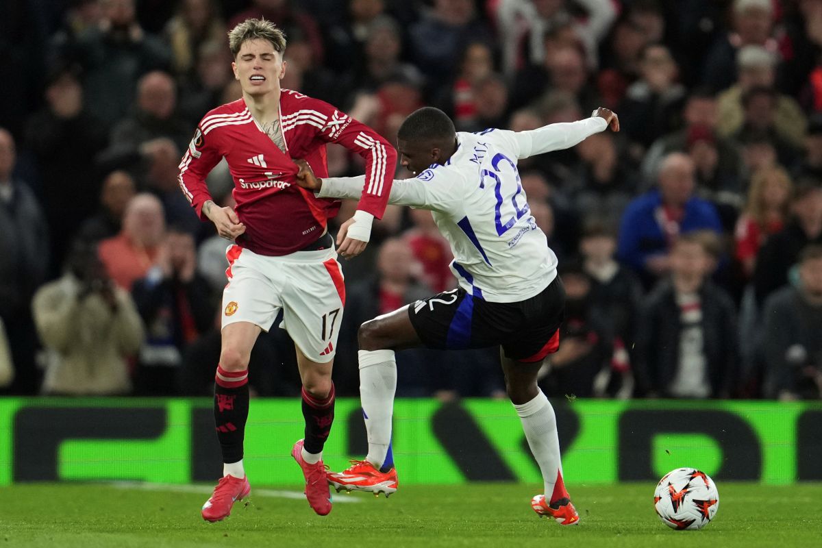 Lyon's Clinton Mata, right, and Manchester United's Alejandro Garnacho challenge for the ball during the Europa League quarter final second leg soccer match between Manchester United and Olympique Lyon in Manchester, Britain, Thursday, April 17, 2025. (AP Photo/Jon Super)