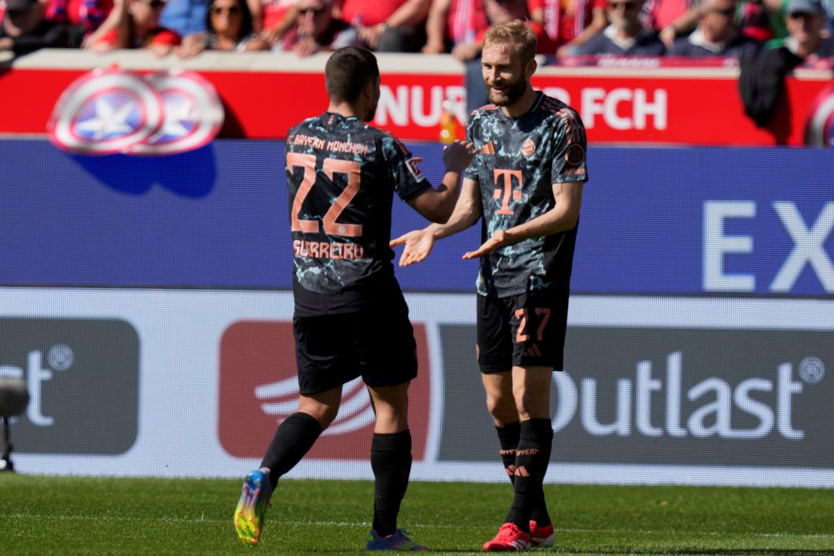 Bayern's Raphael Guerreiro, left, and Bayern's Konrad Laimer celebrate after a goal during the German Bundesliga soccer match between Heidenheim and Bayern Munich in Heidenheim, Germany, Saturday, April 19, 2025. (AP Photo/Matthias Schrader)