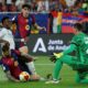 Real Madrid's Vinicius Junior, second left, fights for the ball with Barcelona's goalkeeper Wojciech Szczesny, right, Barcelona's Inigo Martinez, left, and Barcelona's Pau Cubarsi during the Spanish Copa del Rey final soccer match between Barcelona and Real Madrid at Estadio de La Cartuja stadium in Seville, Spain, Saturday, April 26, 2025. (AP Photo/Joan Monfort)