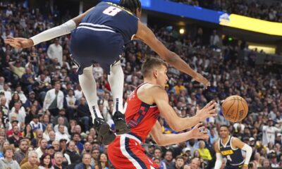 Los Angeles Clippers guard Bogdan Bogdanovic, center, passes the ball as Denver Nuggets forward Peyton Watson, left, defends in the second half of Game 2 of a first-round NBA playoff series Monday, April 21, 2025, in Denver. (AP Photo/David Zalubowski)
