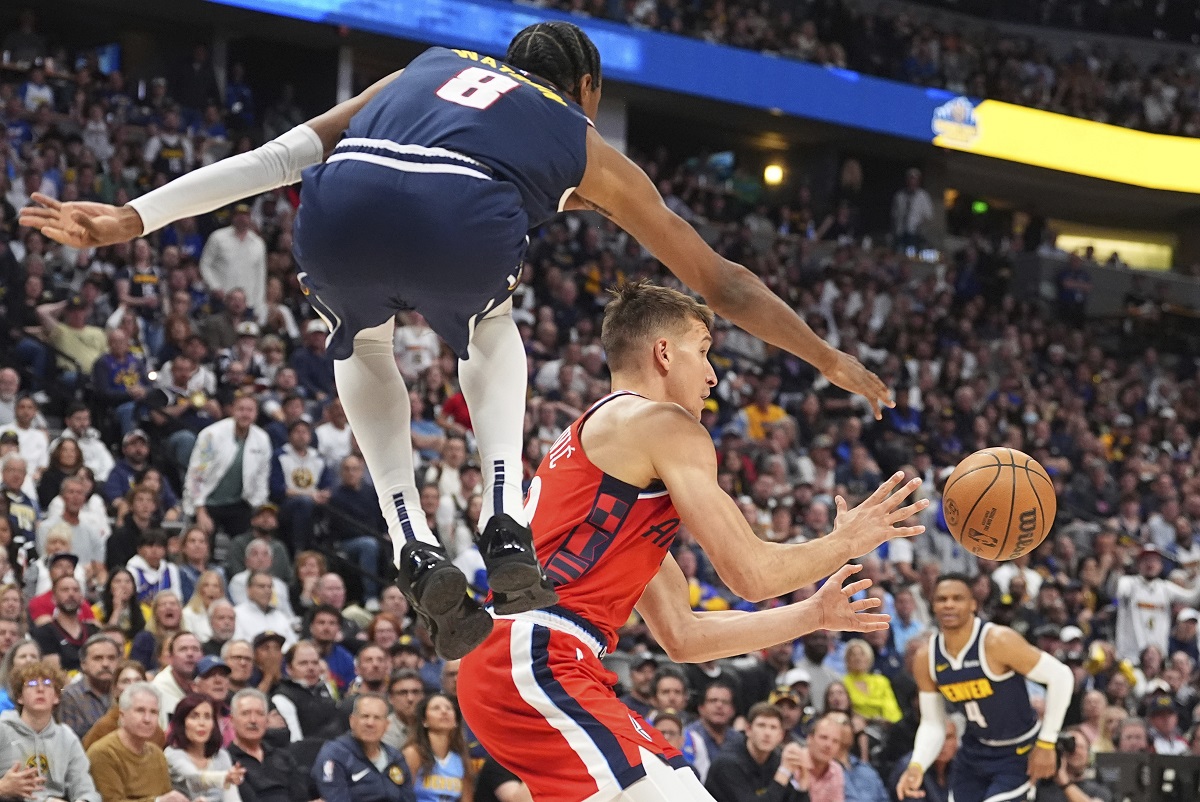 Los Angeles Clippers guard Bogdan Bogdanovic, center, passes the ball as Denver Nuggets forward Peyton Watson, left, defends in the second half of Game 2 of a first-round NBA playoff series Monday, April 21, 2025, in Denver. (AP Photo/David Zalubowski)