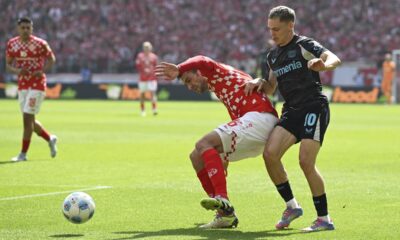 Mainz's Stefan Bell, left and Leverkusen's Florian Wirtz vie for the ball., during the German Bundesliga soccer match between 1. FSV Mainz 05 and Bayer Leverkusen, at the Mewa Arena, in Mainz, Germany, Saturday, May 17, 2025. (Arne Deder/dpa via AP)