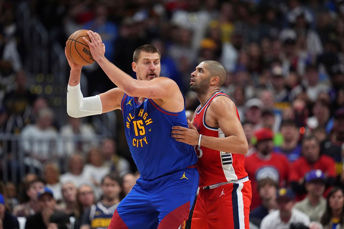 Denver Nuggets center Nikola Jokic, left, looks to pass the ball as Los Angeles Clippers forward Nicolas Batum, right, defends in the second half of Game 7 of an NBA basketball first-round playoff series Saturday, May 3, 2025, in Denver. (AP Photo/David Zalubowski)