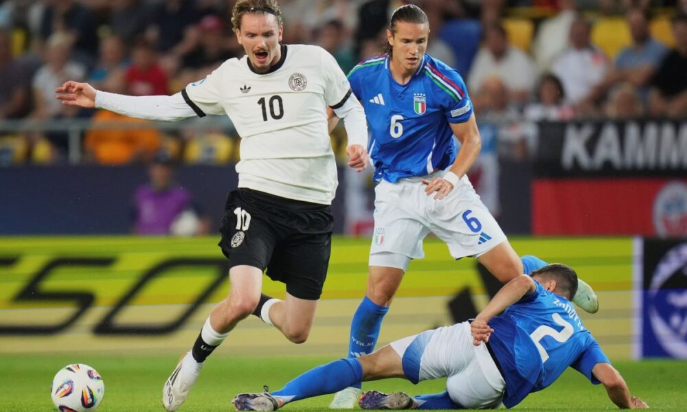 Germany's Nick Woltemade, left, duels for the ball with Italy's Daniele Ghilardi, top right, and Italy's Mattia Zanotti during a quarter final soccer match between Germany and Italy at the European U-21 Championship at the DAC Arena in Dunajska Streda, Slovakia, Sunday, June 22, 2025. (AP Photo/Petr David Josek)
