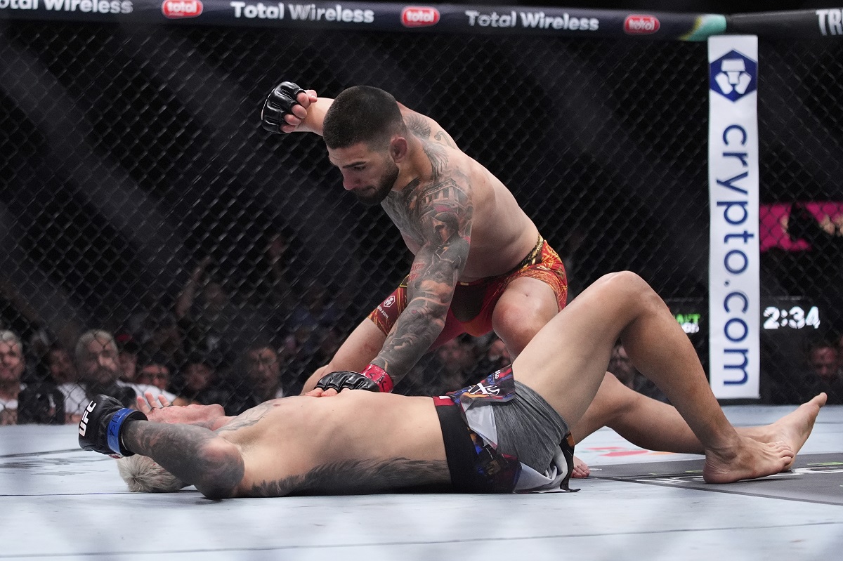 Ilia Topuria pounds on Charles Oliveira in a lightweight title fight at UFC 317, Saturday, June 28, 2025, in Las Vegas. (AP Photo/John Locher)