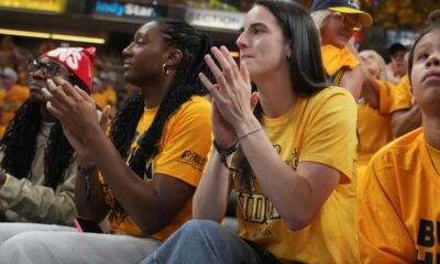 Indian Fever basketball players Caitlin Clark, right, and Aliyah Boston watch during the first half of Game 3 of the NBA Finals basketball series between the Indiana Pacers and the Oklahoma City Thunder, Wednesday, June 11, 2025, in Indianapolis. (AP Photo/Michael Conroy)