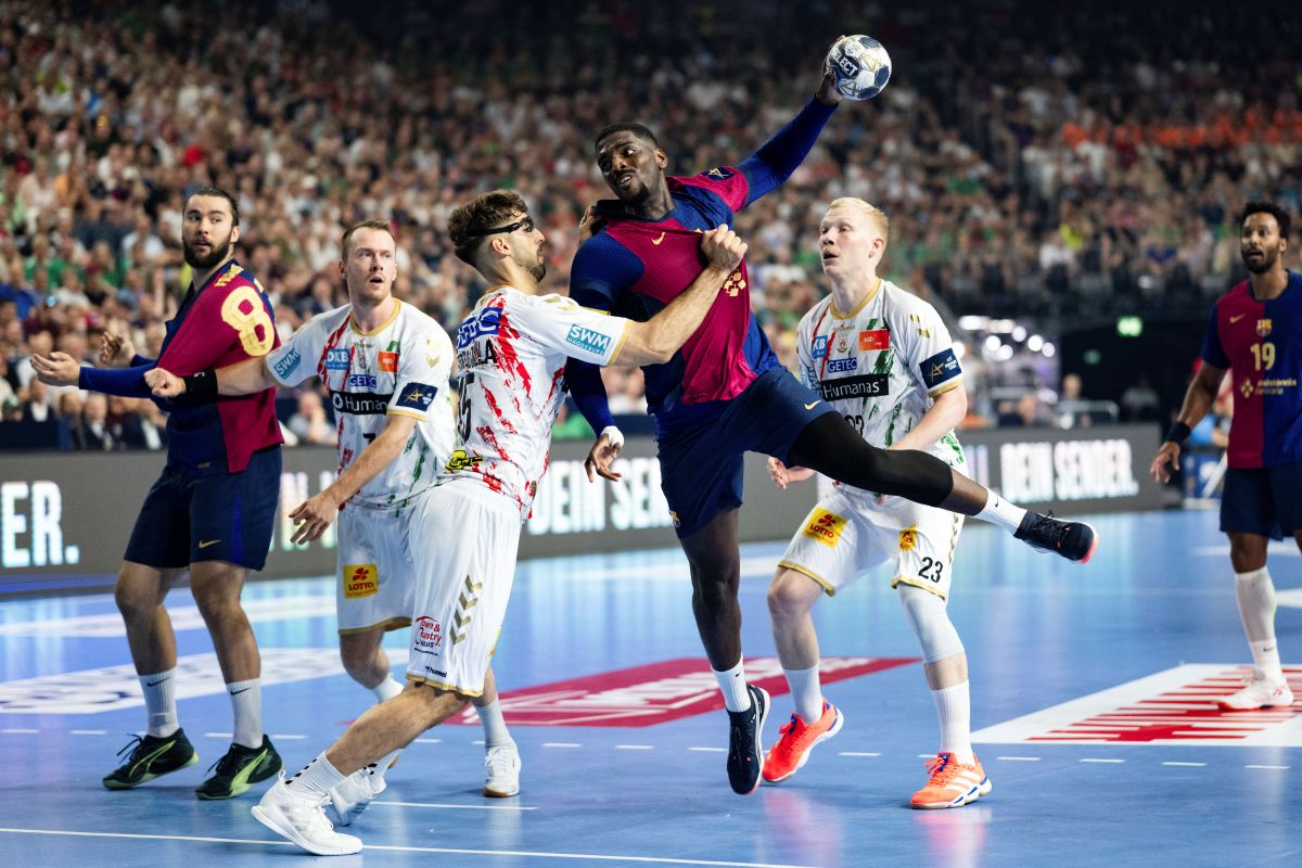 Magdeburg's Antonio Serradilla Cuenca, third left, tries to prevent Barcelona's Rok Ovnicek from taking a shot during the Champions League handball game, semi-final, between FC Barcelona and SC Magdeburg at Lanxess Arena in Cologne, Germany, Saturday June 14, 2025. (Marius Becker/dpa via AP)