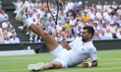 Novak Djokovic of Serbia sits on the grass after diving to return to Miomir Kecmanovic of Serbia during a third round men's singles match at the Wimbledon Tennis Championships in London, Saturday, July 5, 2025. (AP Photo/Kirsty Wigglesworth)
