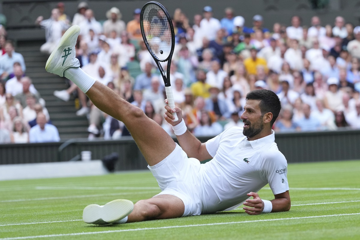 Novak Djokovic of Serbia sits on the grass after diving to return to Miomir Kecmanovic of Serbia during a third round men's singles match at the Wimbledon Tennis Championships in London, Saturday, July 5, 2025. (AP Photo/Kirsty Wigglesworth)