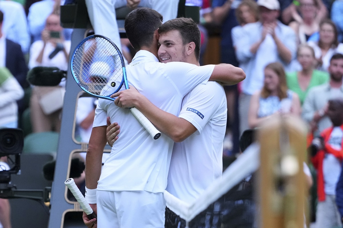 Novak Djokovic of Serbia, left, greets Miomir Kecmanovic of Serbia after winning their third round men's singles match at the Wimbledon Tennis Championships in London, Saturday, July 5, 2025. (AP Photo/Kirsty Wigglesworth)