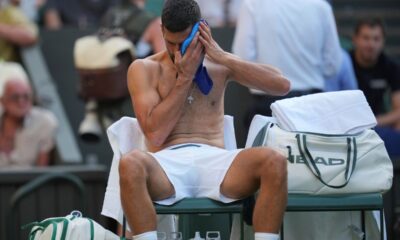 Novak Djokovic of Serbia wipes his face during a break as he plays Alexandre Muller of France during their first round men's singles match at the Wimbledon Tennis Championships in London, Tuesday, July 1, 2025. (AP Photo/Kin Cheung)