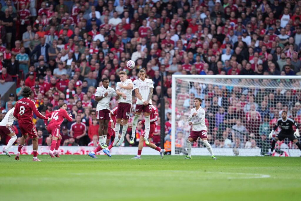 Liverpool's Dominik Szoboszlai, left, shoots to score his sides first goal during the English Premier League soccer match between FC Liverpool and FC Arsenal in Liverpool, England, Sunday, Aug. 31, 2025. (AP Photo/Jon Super)