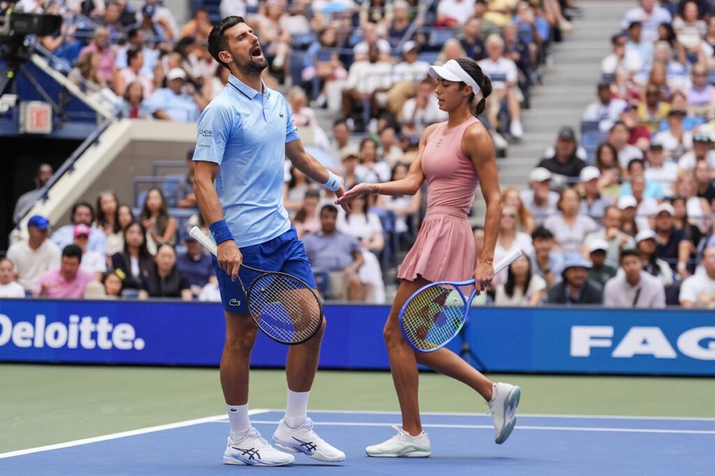 Novak Djokovic, left, of Serbia, and Olga Danilovic, right, of Serbia, interact during their mixed doubles match at the U.S. Open tennis championships, Tuesday, Aug. 19, 2025, in New York. (AP Photo/Yuki Iwamura)