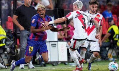 Barcelona's Lamine Yamal, left, is challenged by Rayo's Pep Chavarria during the Spanish La Liga soccer match between Rayo Vallecano and FC Barcelona at the Vallecas stadium in Madrid, Spain, Sunday, Aug. 31, 2025. (AP Photo/Manu Fernandez)