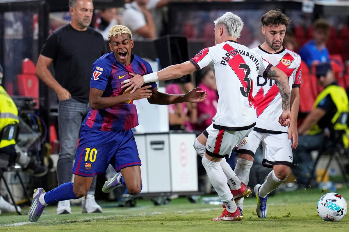 Barcelona's Lamine Yamal, left, is challenged by Rayo's Pep Chavarria during the Spanish La Liga soccer match between Rayo Vallecano and FC Barcelona at the Vallecas stadium in Madrid, Spain, Sunday, Aug. 31, 2025. (AP Photo/Manu Fernandez)