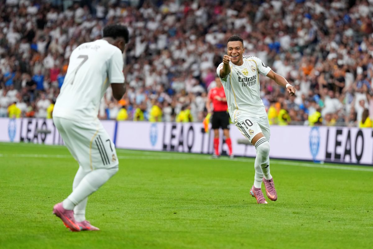 Real Madrid's Kylian Mbappe, right, celebrates with Vinicius Junior after scoring his side's second goal during the Spanish La Liga soccer match between Real Madrid and Espanyol at the Santiago Bernabeu stadium in Madrid, Spain, Saturday, Sept. 20, 2025. (AP Photo/Manu Fernandez)