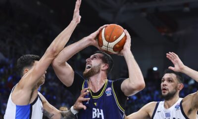 Greece's, Konstantinos Mitoglou, left, and Kostas Papanikolaou, right, defend against Bosnia's Jusuf Nurkic during the Eurobasket, European Basketball Championship Group C match between Greece and Bosnia at Spyros Kyprianou Arena, in Limassol, Cyprus, Tuesday, Sept. 2, 2025. (AP Photo/Chara Savvidou)