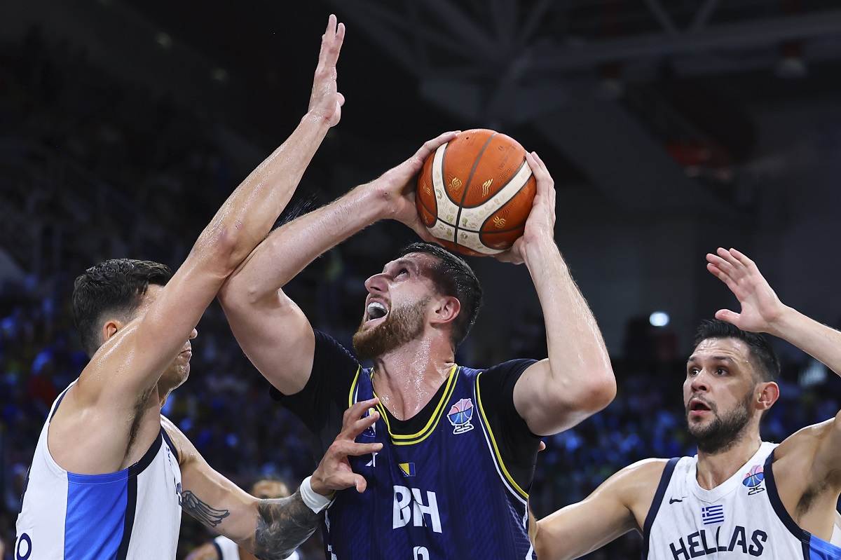 Greece's, Konstantinos Mitoglou, left, and Kostas Papanikolaou, right, defend against Bosnia's Jusuf Nurkic during the Eurobasket, European Basketball Championship Group C match between Greece and Bosnia at Spyros Kyprianou Arena, in Limassol, Cyprus, Tuesday, Sept. 2, 2025. (AP Photo/Chara Savvidou)