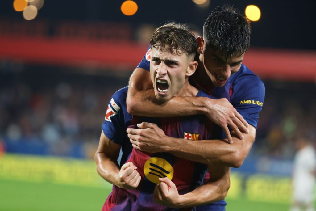 Barcelona's Fermin Lopez celebrates scoring his side's 3rd goal with teammate Gerard Martin during a Spanish La Liga soccer match between FC Barcelona and Valencia at the Johan Cruyff stadium in Barcelona, Spain, Sunday, Sept. 14, 2025. (AP Photo/Joan Monfort)