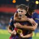 Barcelona's Fermin Lopez celebrates scoring his side's 3rd goal with teammate Gerard Martin during a Spanish La Liga soccer match between FC Barcelona and Valencia at the Johan Cruyff stadium in Barcelona, Spain, Sunday, Sept. 14, 2025. (AP Photo/Joan Monfort)
