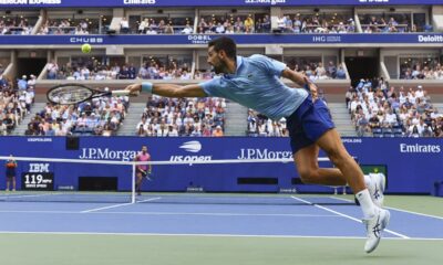 Novak Djokovic, of Serbia, returns a shot to Carlos Alcaraz, of Spain, during the men's singles semifinals of the U.S. Open tennis championships, Friday, Sept. 5, 2025, in New York. (AP Photo/Yuki Iwamura)