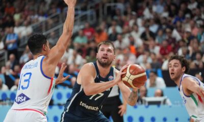 Slovenia's Luka Doncic, centre, tries to shoot while defended by Italy's Simone Fontecchio during the Eurobasket, European Basketball Championship round of 16 match between Italy and Slovenia at the Riga Arena in Riga, Latvia, Sunday, Sept. 7, 2025. (AP Photo/Sergei Grits)