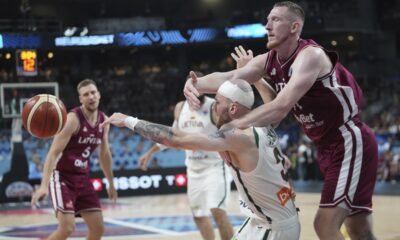 Latvia's Rolands Smits, right, challenges for the ball with Lithuania's Arnas Velicka during the Eurobasket, European Basketball Championship round of 16 match between Lithuania and Latvia at the Riga Arena in Riga, Latvia, Saturday, Sept. 6, 2025. (AP Photo/Sergei Grits)