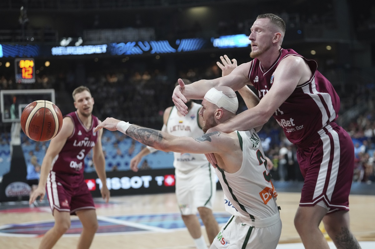 Latvia's Rolands Smits, right, challenges for the ball with Lithuania's Arnas Velicka during the Eurobasket, European Basketball Championship round of 16 match between Lithuania and Latvia at the Riga Arena in Riga, Latvia, Saturday, Sept. 6, 2025. (AP Photo/Sergei Grits)