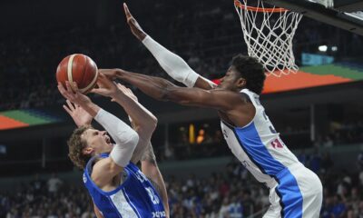 Finland's Lauri Markkanen, centre, tries to shoot while defended by Greece's Kostas Antetokounmpo during the Eurobasket, European Basketball Championship third place match between Greece and Finland at the Riga Arena in Riga, Latvia, Sunday, Sept. 14, 2025. (AP Photo/Sergei Grits)
