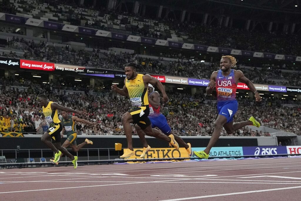 Jamaica's Oblique Seville, left, finishes ahead of Jamaica's Kishane Thompson, center, and United States' Noah Lyles to win the men's 100 meters final at the World Athletics Championships in Tokyo, Sunday, Sept. 14, 2025. (AP Photo/David J. Phillip)