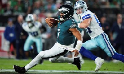 Philadelphia Eagles quarterback Jalen Hurts (1) runs the ball for a gain as Dallas Cowboys defensive end Donovan Ezeiruaku (41) gives chase in the first half of an NFL football game Thursday, Sept. 4, 2025, in Philadelphia. (AP Photo/Matt Slocum)