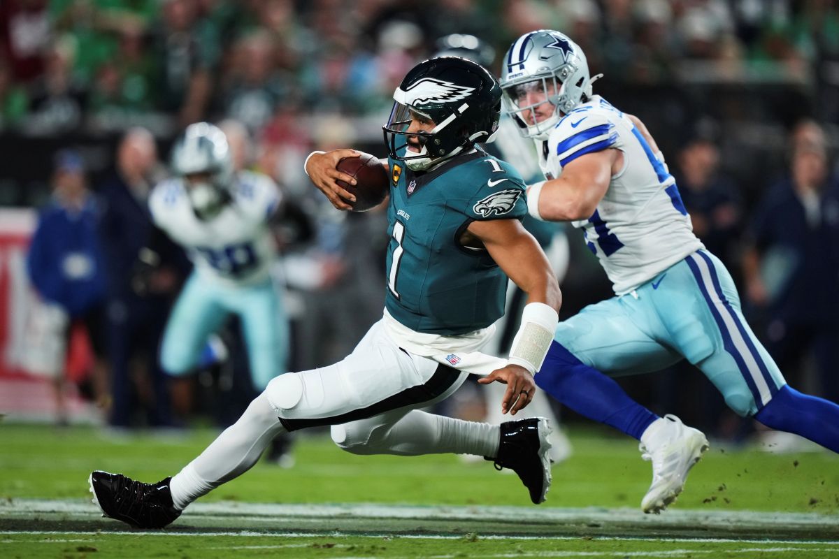 Philadelphia Eagles quarterback Jalen Hurts (1) runs the ball for a gain as Dallas Cowboys defensive end Donovan Ezeiruaku (41) gives chase in the first half of an NFL football game Thursday, Sept. 4, 2025, in Philadelphia. (AP Photo/Matt Slocum)