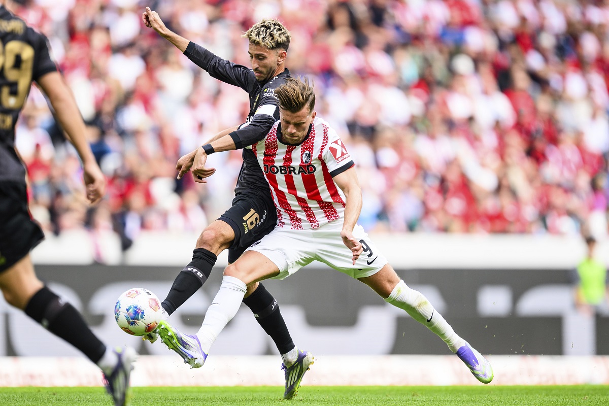 Stuttgart's Atakan Karazor, left, and Freiburg's Lucas Höler, right, challenge for the ball during the Bundesliga soccer match between SC Freiburg and VfB Stuttgart in Freiburg, Germany, Saturday, Sept. 13, 2025. (Tom Weller/dpa via AP)