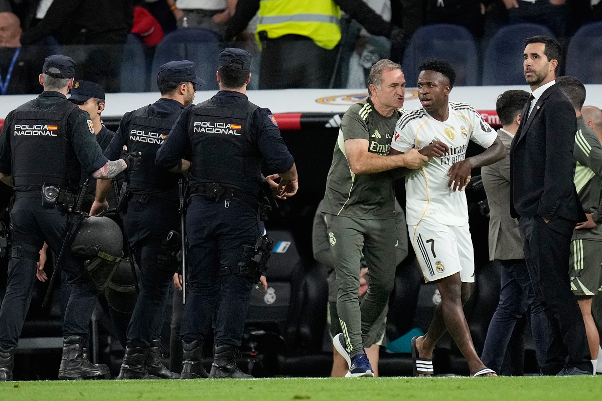 Real Madrid's Vinicius Junior is restrained by coaching staff duringa post match scuffle at La Liga soccer match between Real Madrid and Barcelona in Madrid, Spain, Sunday, Oct. 26, 2025. (AP Photo/Bernat Armangue)