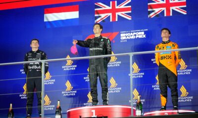 First position winner Mercedes driver George Russell of Britain, center, celebrates on the podium with second place winner Red Bull driver Max Verstappen of the Netherlands, left, and third position winner McLaren driver Lando Norris of Britain during the Singapore Formula One Grand Prix at the Marina Bay Street Circuit in Singapore, Sunday, Oct. 5, 2025. (AP Photo/Vincent Thian)