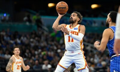 Atlanta Hawks guard Trae Young (11) goes up to shoot in front of Orlando Magic guard Tyus Jones (2) during the first half of an NBA basketball game Friday, Oct. 24, 2025, in Orlando, Fla. (AP Photo/Phelan M. Ebenhack)