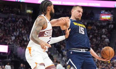 Denver Nuggets center Nikola Jokic, right, looks to pass as Phoenix Suns center Nick Richards defends in the second half of an NBA basketball game Saturday, Oct. 25, 2025, in Denver. (AP Photo/David Zalubowski)