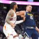 Denver Nuggets center Nikola Jokic, right, looks to pass as Phoenix Suns center Nick Richards defends in the second half of an NBA basketball game Saturday, Oct. 25, 2025, in Denver. (AP Photo/David Zalubowski)