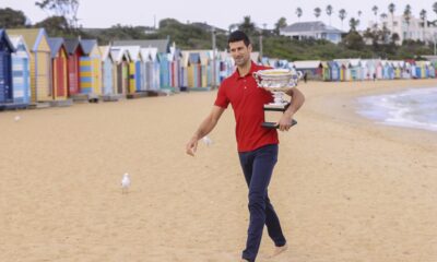 FILE - Serbia's Novak Djokovic carries the Norman Brookes Challenge Cup along Brighton Beach after defeating Russia's Daniil Medvedev on Sunday Feb. 21, 2021 in the men's singles final at the Australian Open tennis championship in Melbourne, Australia, Monday, Feb. 22, 2021.(AP Photo/Hamish Blair,File)