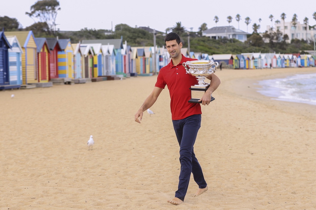 FILE - Serbia's Novak Djokovic carries the Norman Brookes Challenge Cup along Brighton Beach after defeating Russia's Daniil Medvedev on Sunday Feb. 21, 2021 in the men's singles final at the Australian Open tennis championship in Melbourne, Australia, Monday, Feb. 22, 2021.(AP Photo/Hamish Blair,File)