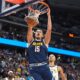 Denver Nuggets center Nikola Jokić, fronbt, dunks the ball for a basket over Indiana Pacers guard/forward Andrew Nembhard in the first half of an NBA basketball game Saturday, Nov. 8, 2025, in Denver. (AP Photo/David Zalubowski)