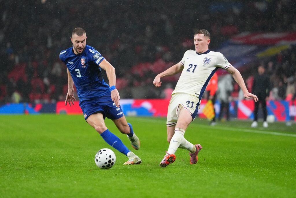 Serbia's Strahinja Pavlovic, left, and England's Elliot Anderson fight for the ball during a World Cup qualifier group K soccer match between Serbia and England in London, Thursday, Nov. 13, 2025. (AP Photo/Kirsty Wigglesworth)