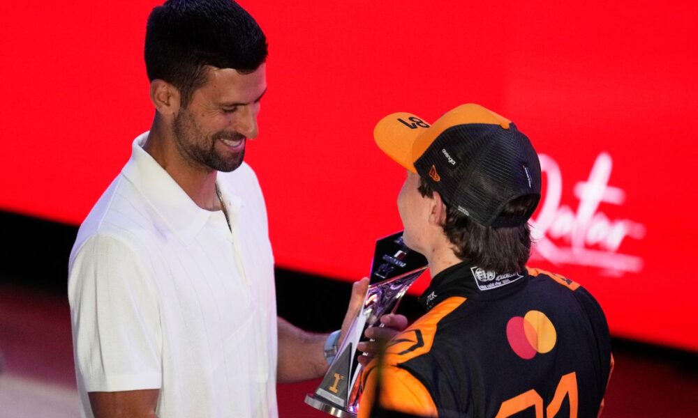 McLaren driver Oscar Piastri of Australia, right, receives the winners trophy from Serbian tennis player Novak Djokovic after the sprint race at the Lusail International Circuit ahead of the Qatar Formula One Grand Prix, in Lusail, Qatar, Saturday, Nov. 29, 2025. (AP Photo/Altaf Qadri)