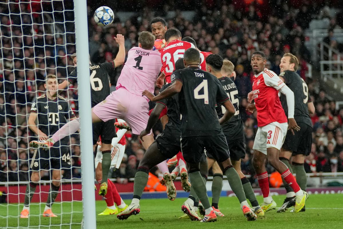 Arsenal's Jurrien Timber, top center, scores the opening goal during the Champions League opening phase soccer match between Arsenal and Bayern Munich in London, Wednesday, Nov. 26, 2025. (AP Photo/Kin Cheung)