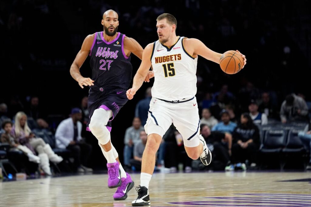 Denver Nuggets center Nikola Jokic (15) works toward the basket as Minnesota Timberwolves center Rudy Gobert (27) defends during the second half of an NBA basketball game, Saturday, Nov. 15, 2025, in Minneapolis. (AP Photo/Abbie Parr)