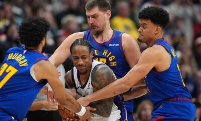 Sacramento Kings guard Demar Derozan, front center, is fouled while handling a pass by, from left, Denver Nuggets guard Jamal Murray, center Nikola Jokić and forward Spencer Jones in the second half of an NBA basketball game Saturday, Nov. 22, 2025, in Denver. (AP Photo/David Zalubowski)