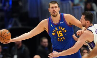 Denver Nuggets center Nikola Jokić, left, looks to pass the ball as Sacramento Kings center Drew Eubanks, right, defends in the first half of an NBA basketball game Saturday, Nov. 22, 2025, in Denver. (AP Photo/David Zalubowski)