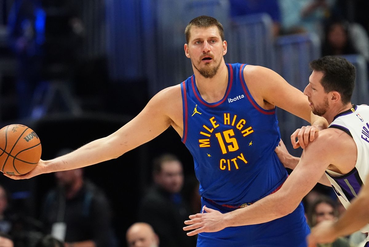 Denver Nuggets center Nikola Jokić, left, looks to pass the ball as Sacramento Kings center Drew Eubanks, right, defends in the first half of an NBA basketball game Saturday, Nov. 22, 2025, in Denver. (AP Photo/David Zalubowski)